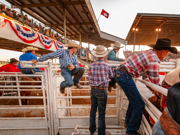 Men with hats watching the rodeo